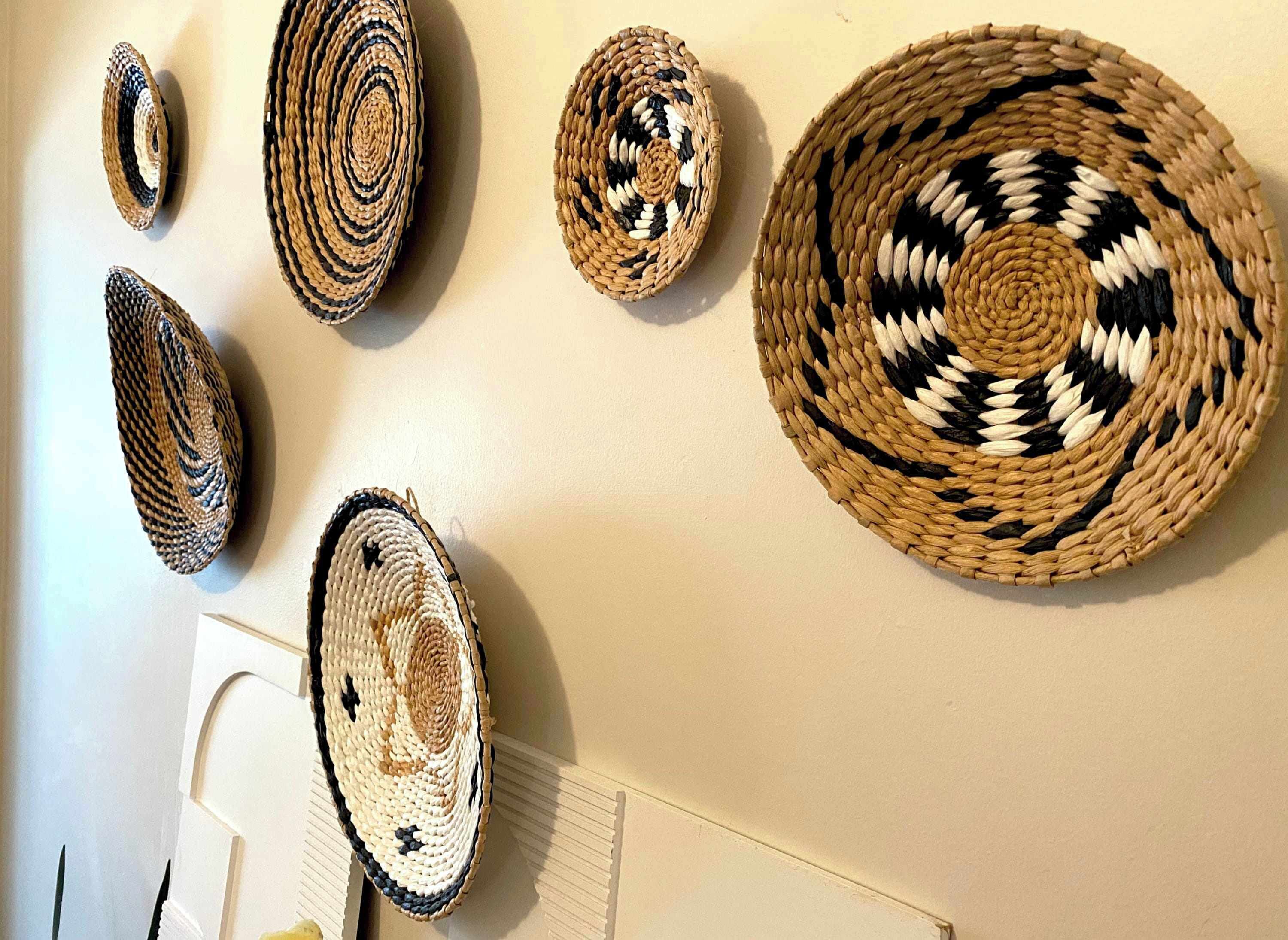 A wall with various woven baskets of different sizes and patterns.
