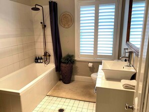 Bathtub, rainfall showerhead, hair dryer, towels