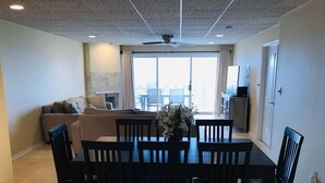 A dining area with a table, chairs, and a vase of flowers.