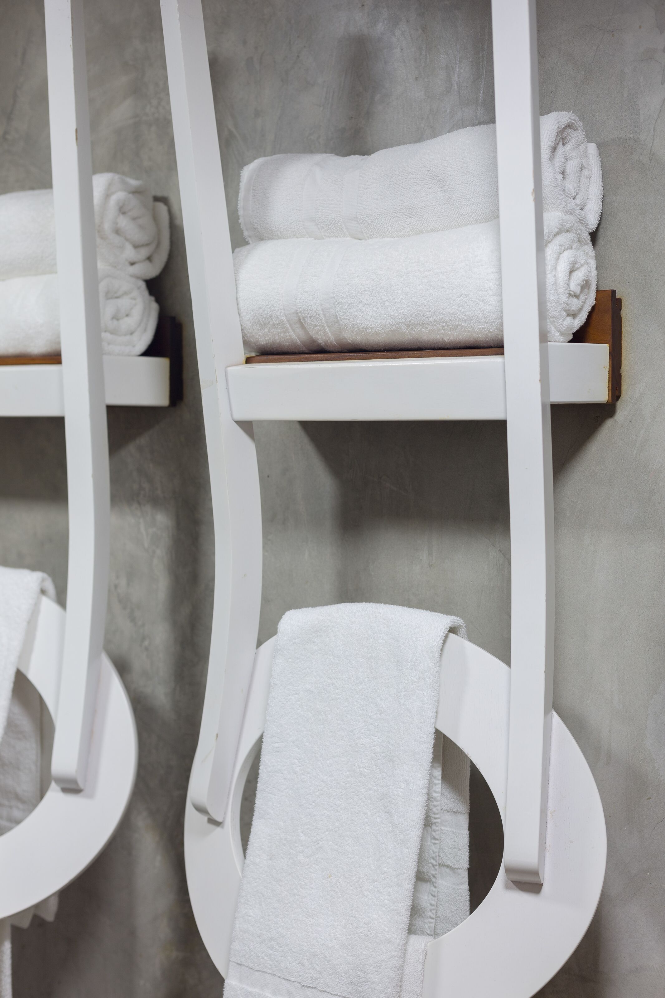 A bathroom with white towel racks and shelves.