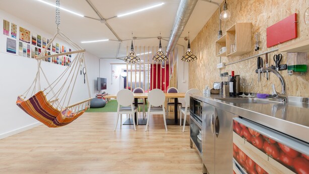 A modern kitchen with a wooden countertop, stainless steel appliances, and a hanging chair. - Tomate Rooms (Alicante)