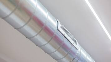 Conductos metálicos con una abertura rectangular, probablemente para ventilación o aire acondicionado.