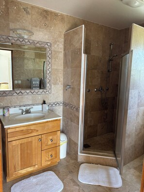 A bathroom with a wooden vanity, a sink, a mirror, a shower with a glass door, and a tiled floor. - Enjoy Your Front Row Villa On The Adriatic Sea (Pisak)