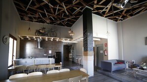 A modern kitchen with a central island, wooden ceiling beams, and pendant lighting.
