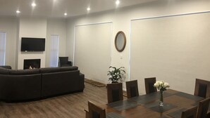 A modern living room with a sectional sofa, a flat-screen TV, and a fireplace.