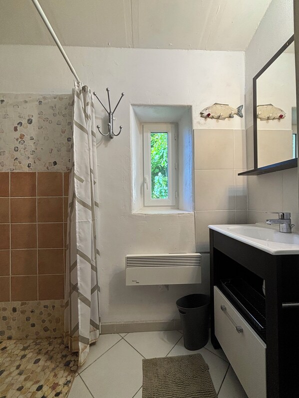 A bathroom with a shower, a window, a sink, and a mirror. - Loft in a lovely farm-house on the Mont-Ventoux's country side (Entrechaux)
