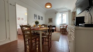 Un espace repas comprenant une table ronde, des chaises et un luminaire suspendu.