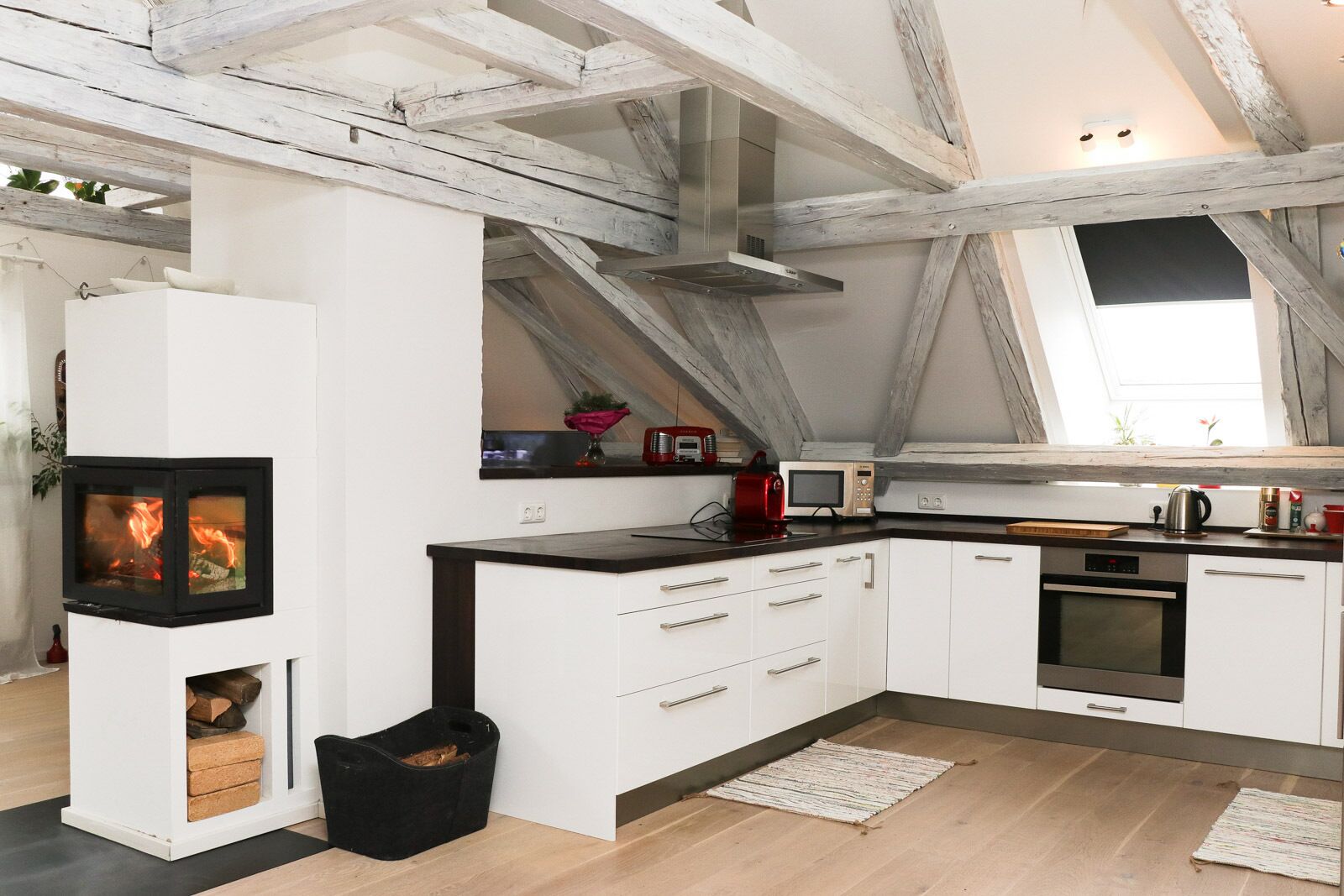 A modern kitchen with white cabinets, a built-in stove, and a black countertop.