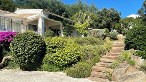 A building with a covered patio, stone steps, and lush greenery. - Côte d'Azur, luxury domestic villa, pool, air conditioning, sea view (La Croix-Valmer)