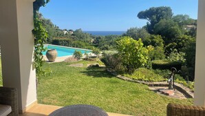 A patio with a view of a swimming pool and ocean. - Côte d'Azur, luxury domestic villa, pool, air conditioning, sea view (La Croix-Valmer)