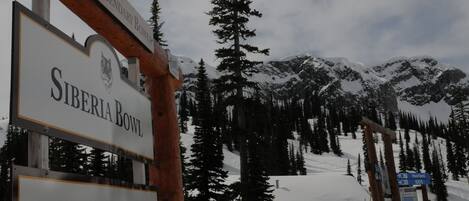 A sign for the Siberia Bowl ski resort with a mountainous backdrop.