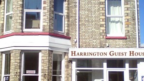 A two-story building with a stone facade and a sign reading "Harrington Guest House." - Harrington Flats (Newquay)