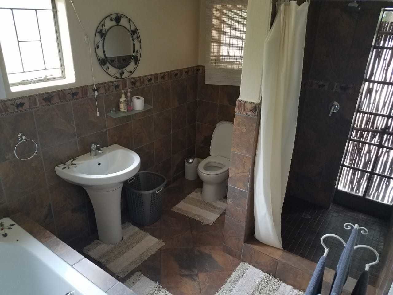 Une salle de bain comprenant un lavabo, des toilettes et un espace douche.