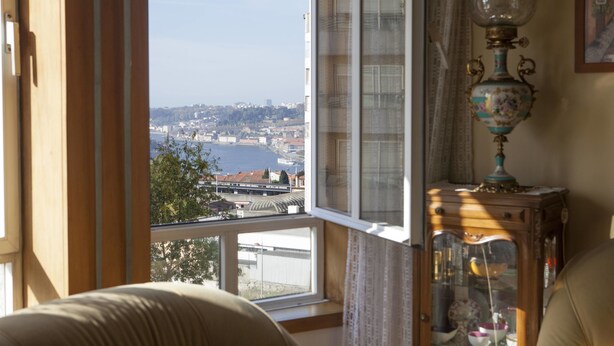 Una habitación con un amplio ventanal que da a una vista panorámica de la ciudad y el agua.