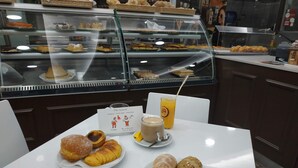 Una mesa con pasteles, una bebida y un menú en un café.