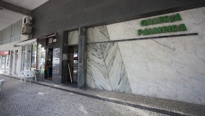Exterior de un edificio con un cartel que dice "GALERIA PALMEIRA" y piso de baldosas.