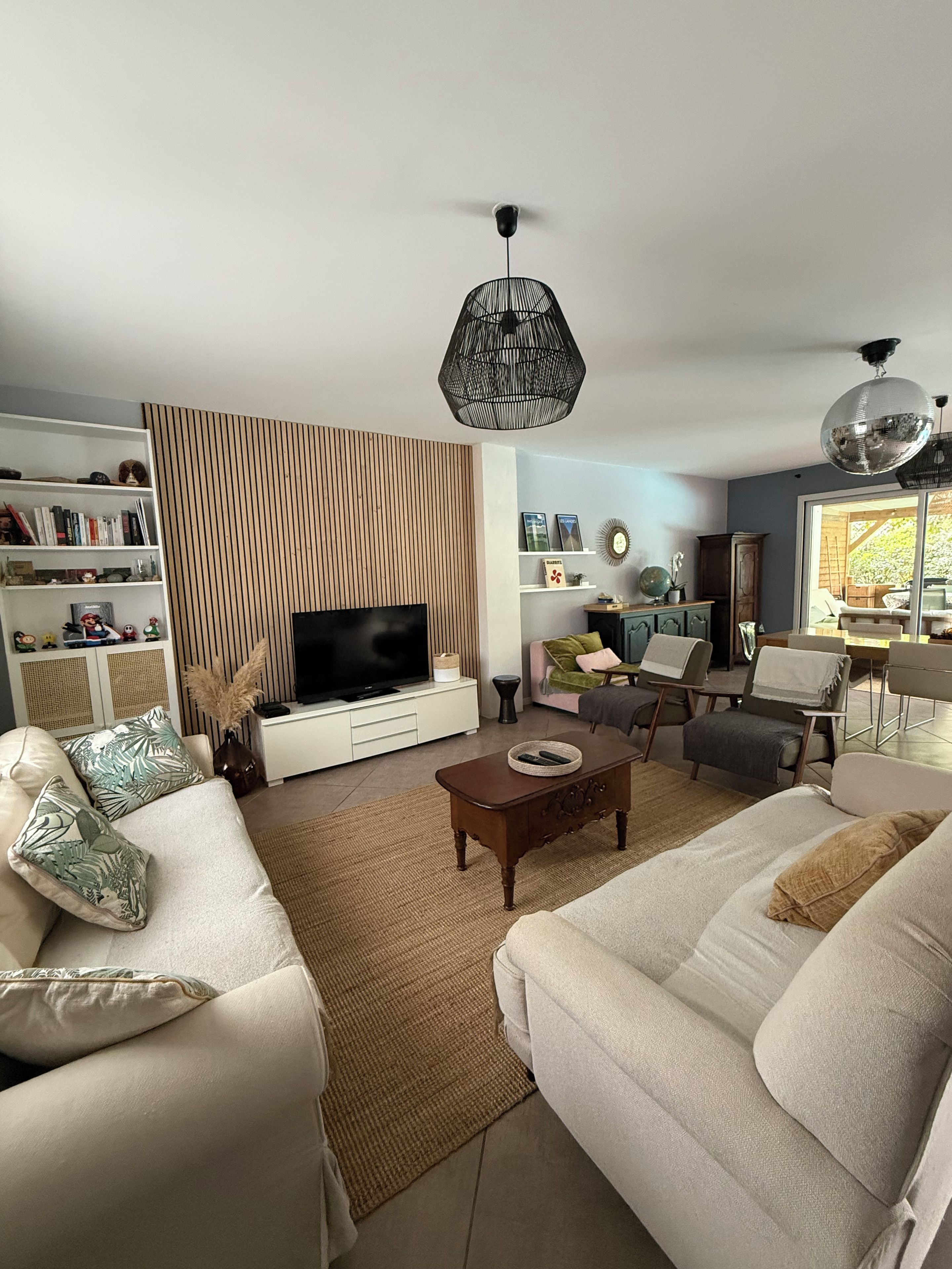 A living room with a television, sofa, coffee table, and decorative items.