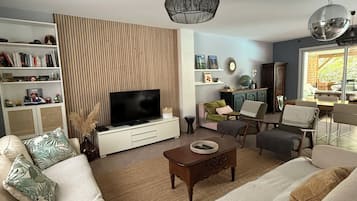 A living room with a television, sofa, coffee table, and decorative items.