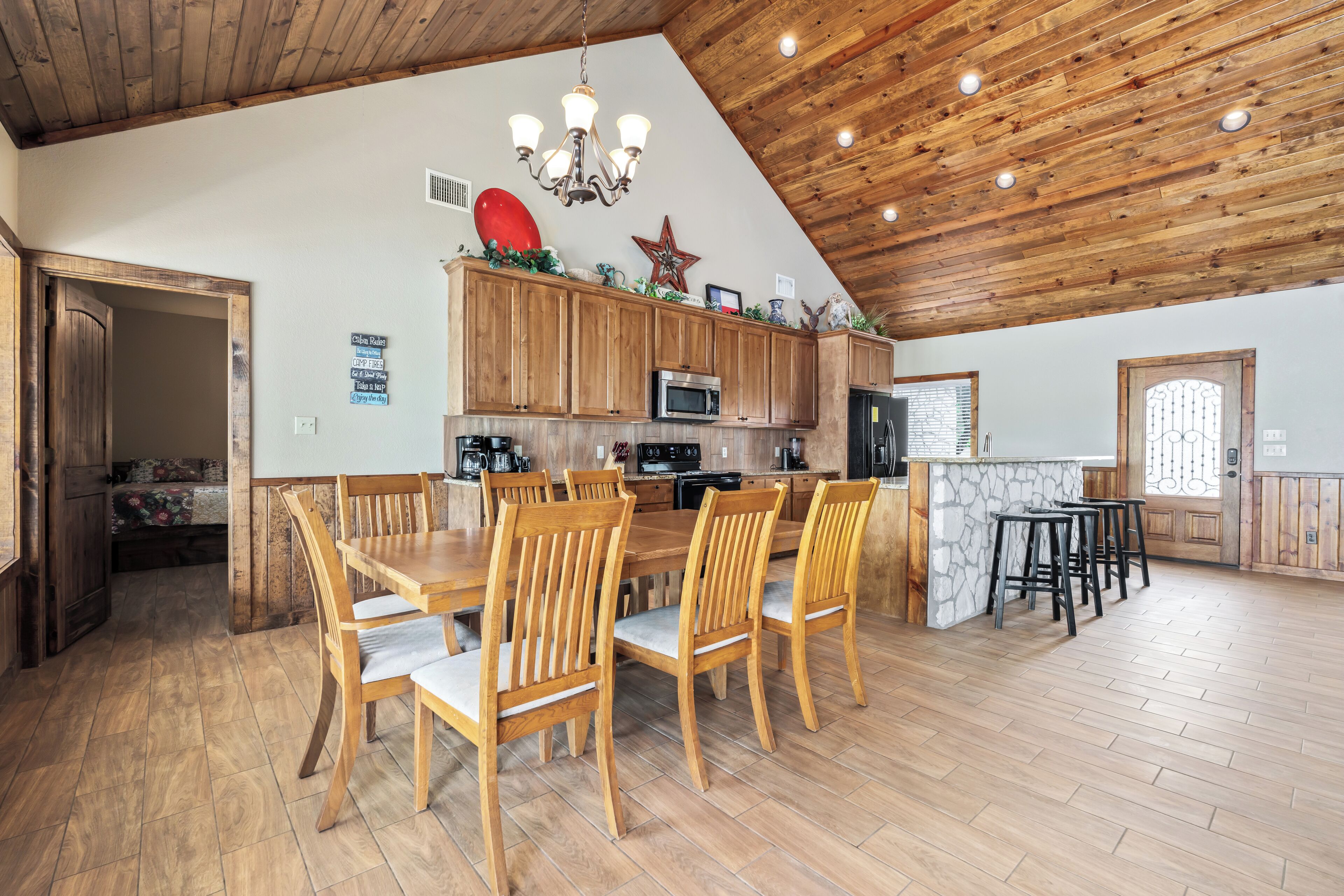 Una cocina amplia con armarios de madera, una mesa de comedor con sillas y una zona de bar.