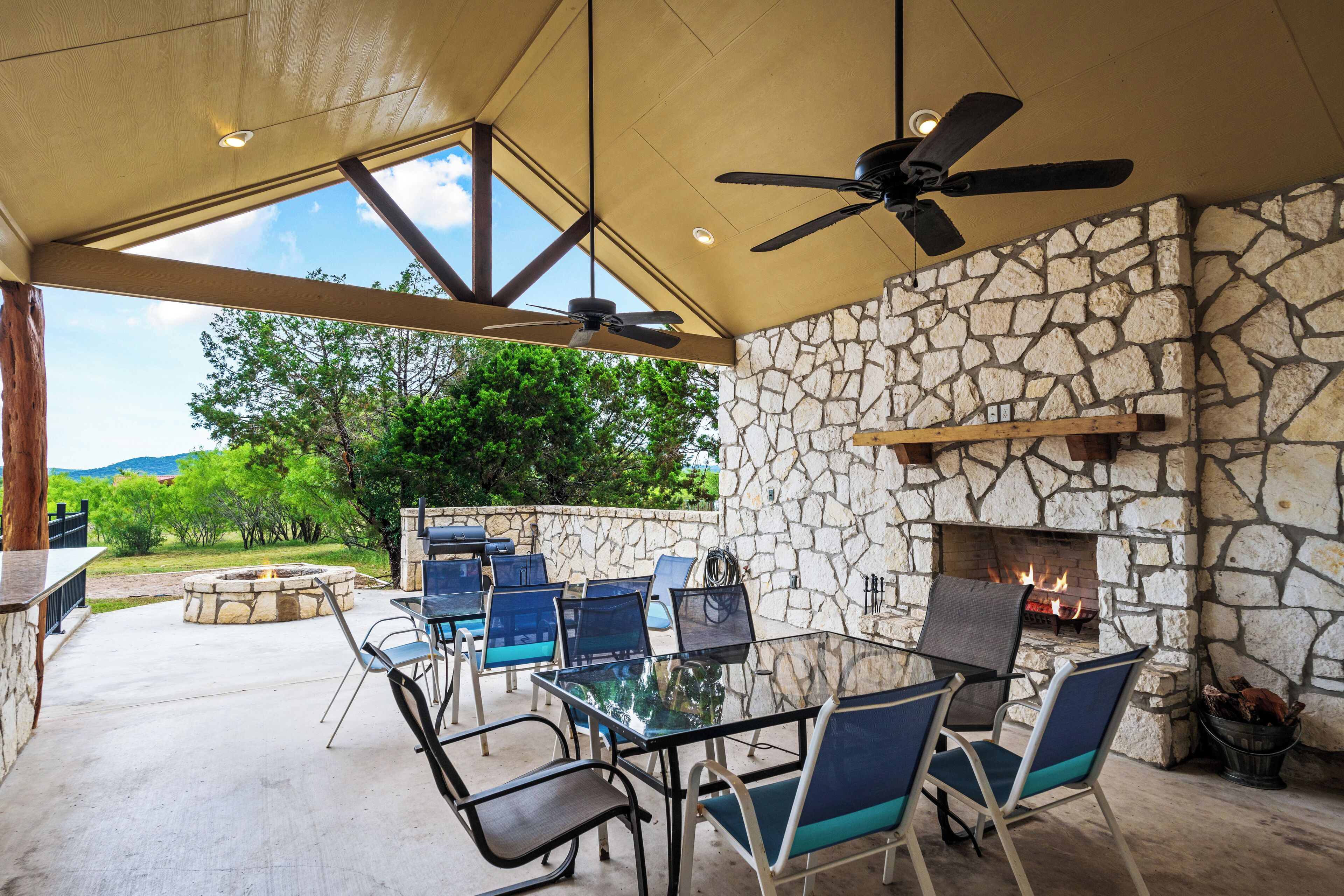 An outdoor patio with stone walls, a glass table, and chairs.