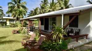 A house with a porch, outdoor seating, and a lawn with palm trees. - Mac's Shack - Titikaveka (Titikaveka)