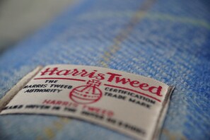 Gros plan d’une étiquette en Harris Tweed sur un tissu en denim.