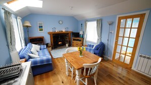 Ein gemütliches Wohnzimmer mit einem blauen Sofa, einem Holzesstisch und einem Kamin.