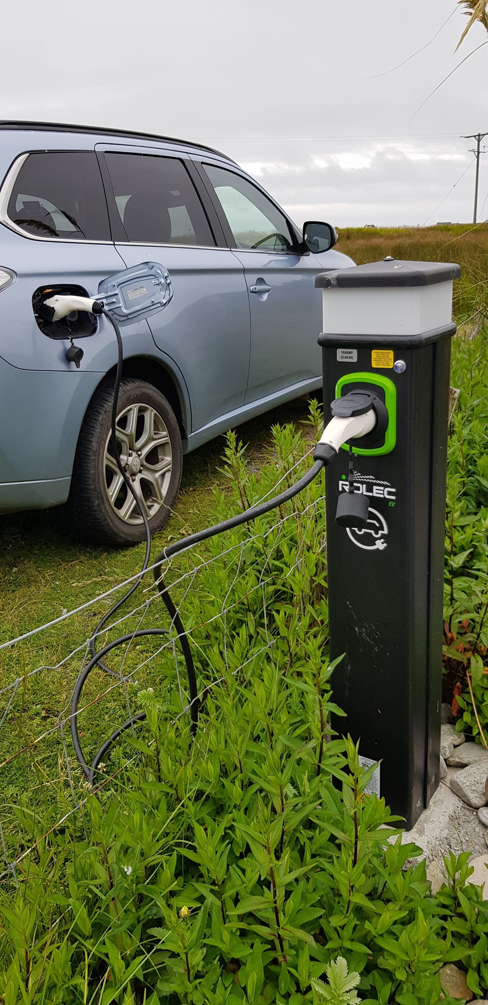 A car charging at an outdoor electric vehicle charging station.