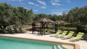 A pool area with lounge chairs and a gazebo. - Sun, sea, calm and space in a finca 6.5 ha, Casita Tres (El Perelló)