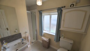 Une salle de bain avec un lavabo, des toilettes et une douche.