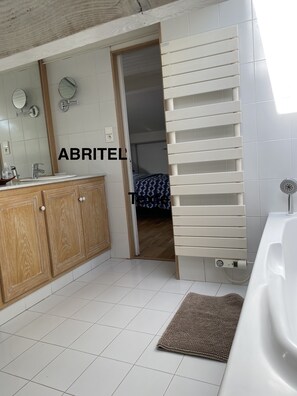 Banheira, secador de cabelo, toalhas de banho, papel higiênico