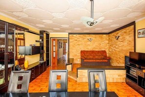 Relax in the stylish living room with a sofa, dining table, and flat-screen TV.