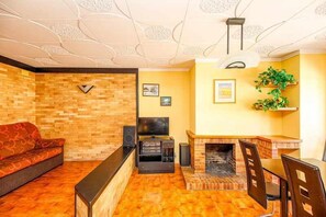 Relax in this inviting living space with a comfortable sofa, flat-screen TV, and cozy fireplace.