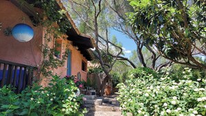 A traditional building with a stone pathway leading to a wooden door. - Garden Villa near Costa Smeralda (Olbia)