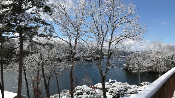 A snow-covered deck overlooking a lake with trees and a small building. - Cozy Waterfront Cottage -- No Wake Cove, Great Views, New Private Floating Dock (Huddleston)