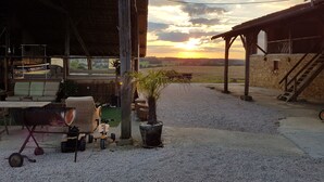 A rustic outdoor seating area with a view of the sunset.