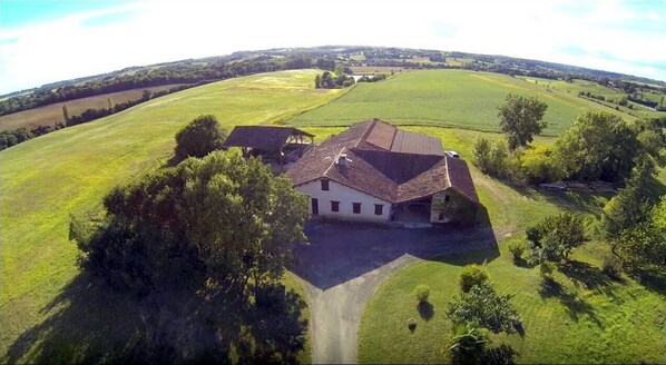 A large house with a spacious driveway and a well-maintained lawn, surrounded by open fields and trees. - Ferme d'Antan Gers 2 party rooms 30+ heated pool spa .private lake fishing. (lupiac)