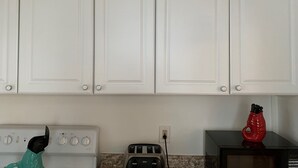 A kitchen with white cabinets, a white stove, a toaster, and a red appliance on the counter. - 3 Bdr Vacation Rental - Walk To The Beach (Old Orchard Beach)