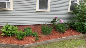 A house with a garden bed in front. - 3 Bdr Vacation Rental - Walk To The Beach (Old Orchard Beach)