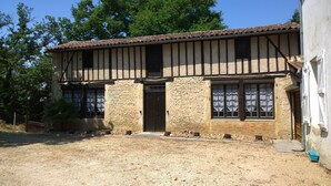 A traditional building with a tiled roof, stone walls, and multiple windows. - the cottages of castera NORMANDIE (Aire-Sur-L'adour)