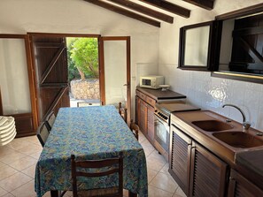 Une cuisine équipée d’une table, de chaises, d’un four à micro-ondes et d’un évier.