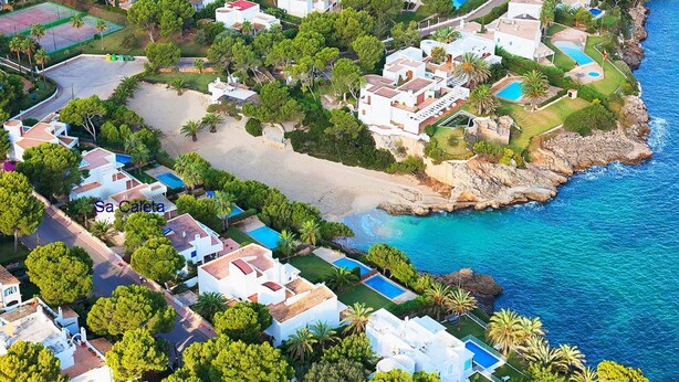 An aerial view of a coastal residential area with houses, a beach, and a clear blue sea. - VILLA SA CALETA:  6 beds, 5 baths  Front line Villa In Es Forti, Cala d´Or (Santanyí)
