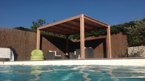 A wooden gazebo by a pool with a clear blue sky. - House near La Cotinière -WIFI -heated pool -classified 4* Charente Tourisme (Saint-Pierre-d'Oléron)