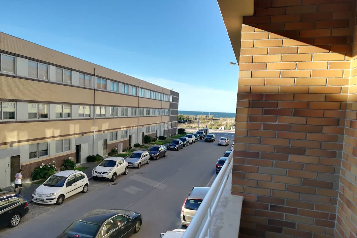 Ein Parkplatz mit mehreren Autos vor einem Gebäude mit Ziegelaußenwand.