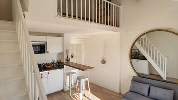 A modern loft-style apartment with a kitchen, dining area, and living space.