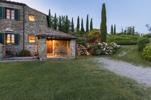 A stone house with a small patio and a garden. - Villa Mulinoavento with magnificent view 5 minutes walking downtown (Cortona)