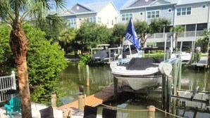 A marina with boats docked, a dining area with outdoor seating, and a view of residential buildings in the background. - Key West Style Townhome  Intercoastal Waterviews!!!
 (Indian Rocks Beach)