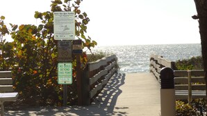 A wooden boardwalk leading to a beach with signs about sea turtle conservation, a no dogs sign, and a bench. - Key West Style Townhome  Intercoastal Waterviews!!!
 (Indian Rocks Beach)