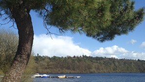 A lakeside scene with a dock and boats, surrounded by trees and a clear sky. - Idyllic Rural Retreat. Pool & Games Room. IDEAL COUPLES, FAMILY OR INDEPENDENTS (Lanrivain)