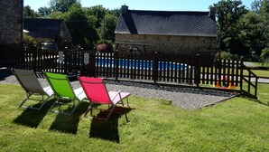 A stone building with a fenced pool area, outdoor chairs, and a clear sky. - Idyllic Rural Retreat. Pool & Games Room. IDEAL COUPLES, FAMILY OR INDEPENDENTS (Lanrivain)